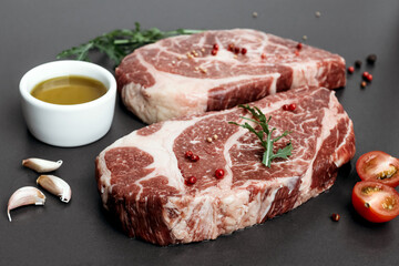 Raw marbled steak on black background.