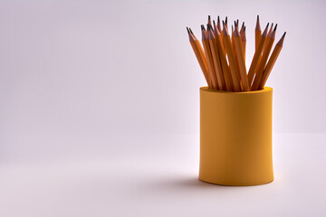 pencils in a yellow glass on a white background