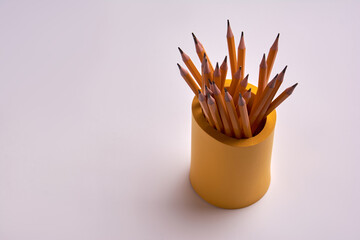 pencils in a yellow glass on a white background