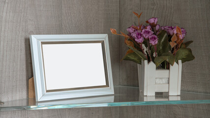 empty white wooden photo frame on glass shelf with flower pot