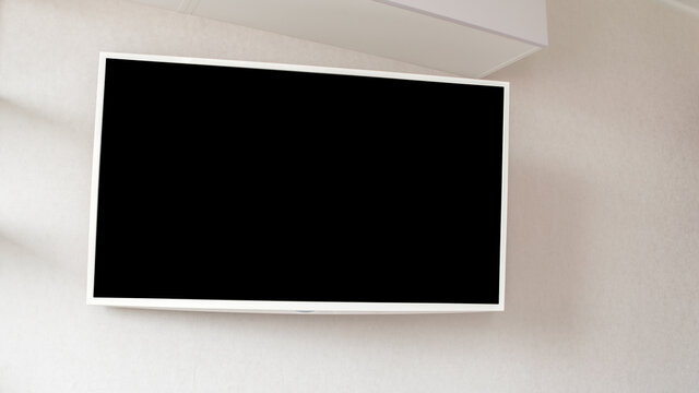 empty black screen of modern plasma tv hanging on wall of room