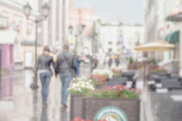 Abstract silhouettes of people after rain in city, young couple together seen through raindrops on window glass, blurred background