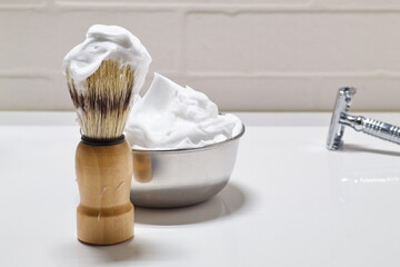 Fototapeta na wymiar shaving set with blade, brush and bowl with foam