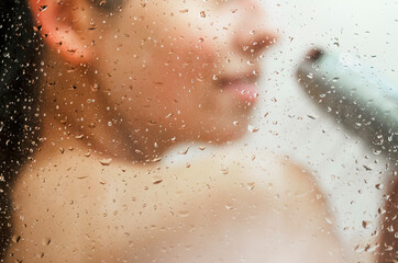 Young woman taking shower. Concept of simple pleasures, relaxing and healthcare