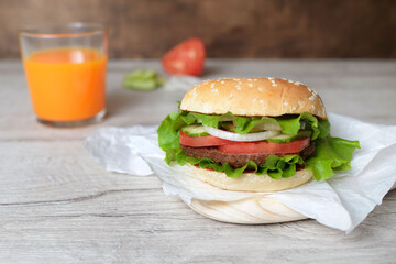 burger on a wooden background with carrot juice