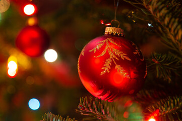 Christmas ornaments hanging in an illuminated balsam fir Christmas tree.