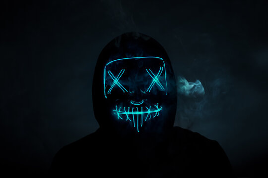 Portrait of an anonymous hacker in a neon mask, Halloween mask