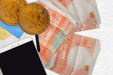3 cuban pesos convertibles bills and golden bitcoins with smartphone and credit cards....