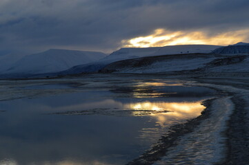 Sunset reflections over the frozen Arctic Norwegian Archepelago of Svalbard, Norway