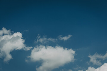 White cotton wool clouds on a sunny day. A continuous stream of clouds across the summer sky.