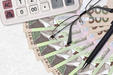 500 Ukrainian hryvnias bills fan and calculator with glasses and pen. Business loan or tax payment...