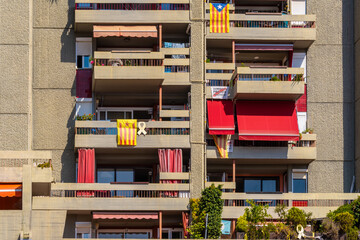Badalona, Spain - September 08, 2020. Balconies with stellate flags, yellow ribbons and posters in support of the supposed political prisoners of Catalonia, Spain