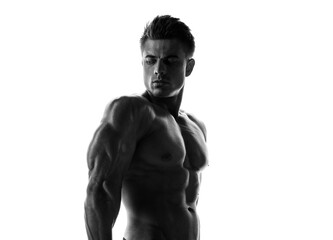 Fototapeta premium Muscular model sports young man on white background. Black and white fashion portrait of strong brutal guy. Sexy torso. Male flexing his muscles.