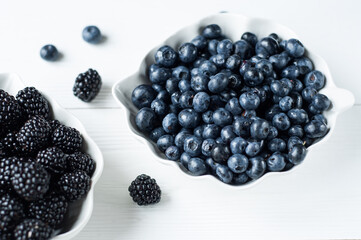 Background of fresh fruits and berries. Ripe blackberries, blueberries, plums, raspberries. Mix berries and fruits. Top view. Background berries and fruits. Black-blue and red food.