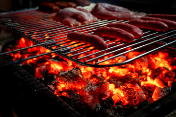 View of a half-done barbecue with sausages, hamburgers, pork and bacon. Selective focus