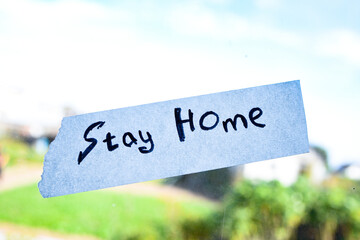 a sign that says stay home on the window. a call to stay at home. self-isolation concept
