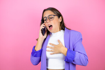 Young beautiful business woman over isolated pink background on the phone with a worried expression