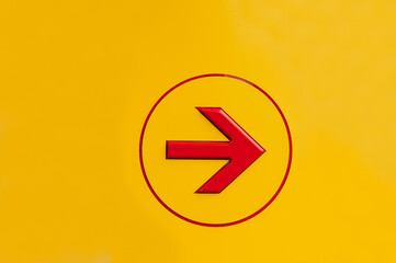 Red color paint arrow sign in white circle sharpe on yellow background. Go right arrow sign for...