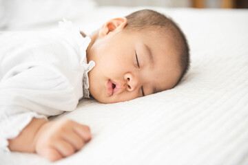 Newborn asian baby girl sleep on white bed relaxing feelgood happy. people health care concept.