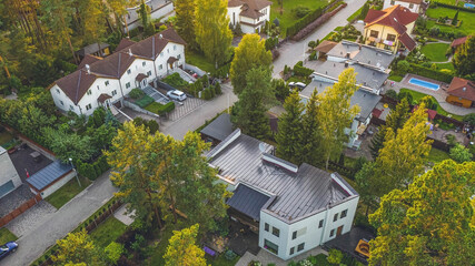 Top drone view of private sector of modern city. Luxury architecture. Road and houses. Green trees.