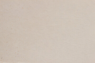 Texture of the cardboard, cream color with various dirt specks, folds, wrinkles. Natural rough paper background
