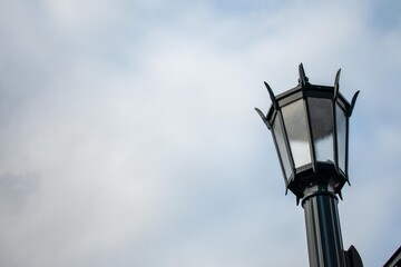 Fototapeta na wymiar An Old Fashioned Black Metal Lamp Post on a Clear Blue Sky