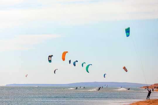 a kitesurfer surfing on the smooth azure water. recreational sport. A Man Rides A Kiteboarding In The Sea Water. extreme sport. Jump