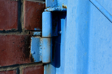 Hinged iron hinges on garage doors in blue