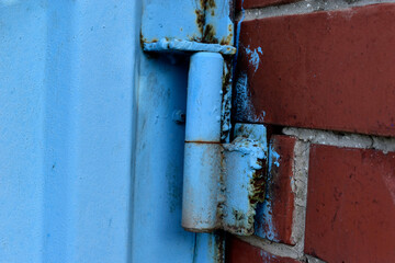 Hinged iron hinges on garage doors in blue