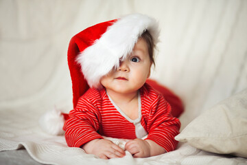 Smiling happy baby in christmas santa's hat and red overalls - 376748240