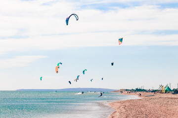 a kitesurfer surfing on the smooth azure water. recreational sport. A Man Rides A Kiteboarding In The Sea Water. extreme sport. Jump