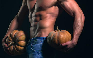 Halloween man, party poster or greeting card. Shirtless athletic man hold pumpkin turned back on...
