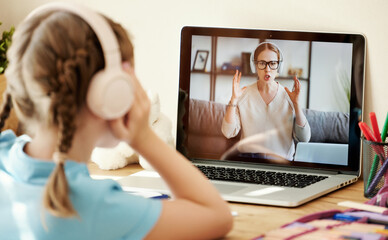 Girl listening to angry teacher during online lesson.