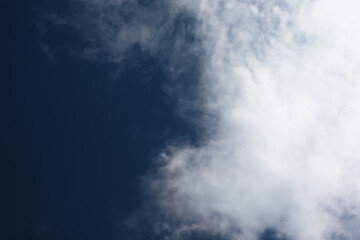 White cotton wool clouds on a sunny day. A continuous stream of clouds across the summer sky.