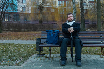middle adult calm bearded man sitting on bench lonely melancholy mood in autumn park dray ordinary...