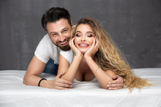 Young happy couple lying together in bed