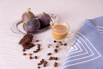 a cup of coffee with milk, 3 figs and chocolate