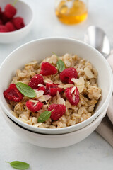 Oatmeal with raspberries, honey, almond petals. Healthy breakfast.