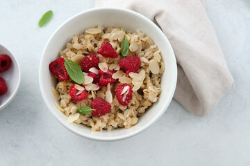Oatmeal with raspberries, honey, almond petals. Healthy breakfast.