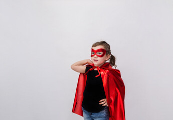 Portrait of a little girl in a supergirl costume on a white background