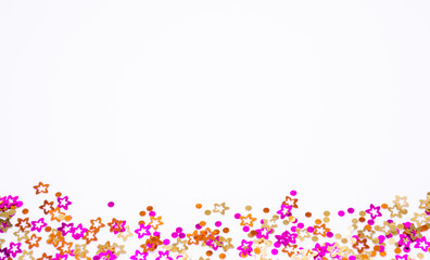 Scattered round confetti and in the form of flowers pink, gold and orange color on a white background. Copy space. Spring and summertime, birthday and wedding concept