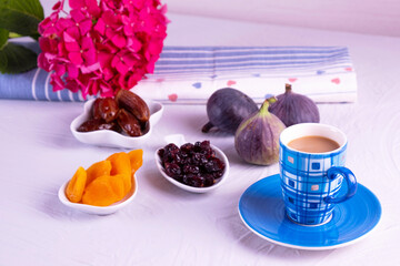 a cup of coffee with milk, dried fruits and fresh figs