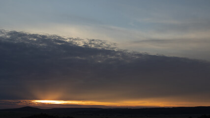 Sky 16: 9, sunset with rays under the clouds