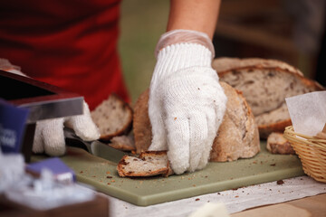 Chef cuts fresh homemade bread on the table close-up
