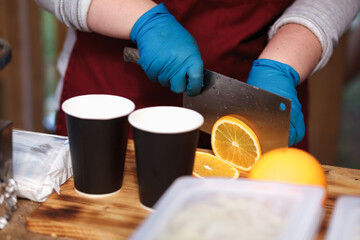 person cuts oranges for cocktail