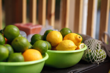 lemons and limes in green bowl on the counter