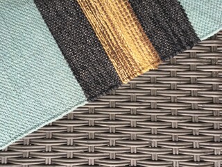 Gray wicker texture and woven multi-colored carpet. Background for website design, screen, banner. High quality photo