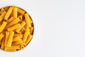 Raw dry uncooked Tortiglioni pasta spaghetti noodle on white bowl wooden background for basil tomato pesto sauce Homemade Italian food organic whole wheat vegan spaghetti for a healthy meal