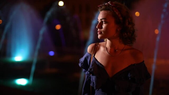 Beautiful woman fashion model posing at night city in slow motion