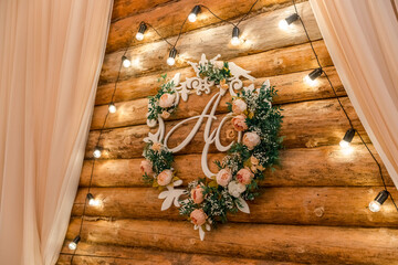 Wedding decor  in rustic style. Decorative wreath of white and pink roses and green leaves with the...